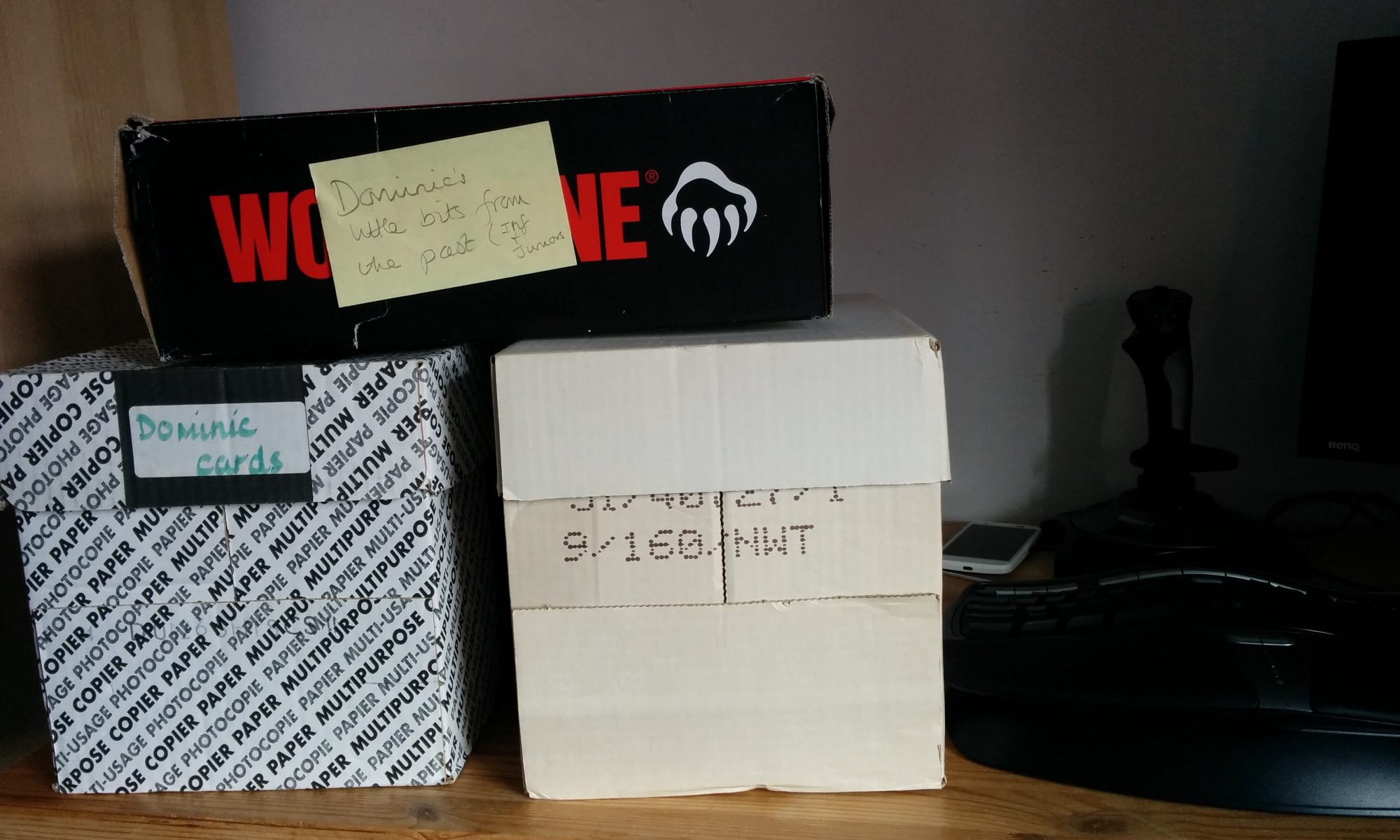 A collection of filing boxes with a post-it note that reads "Dominic's little bits from the past"